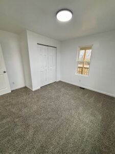 Unfurnished room with gray carpet, white walls, and a window providing natural light.